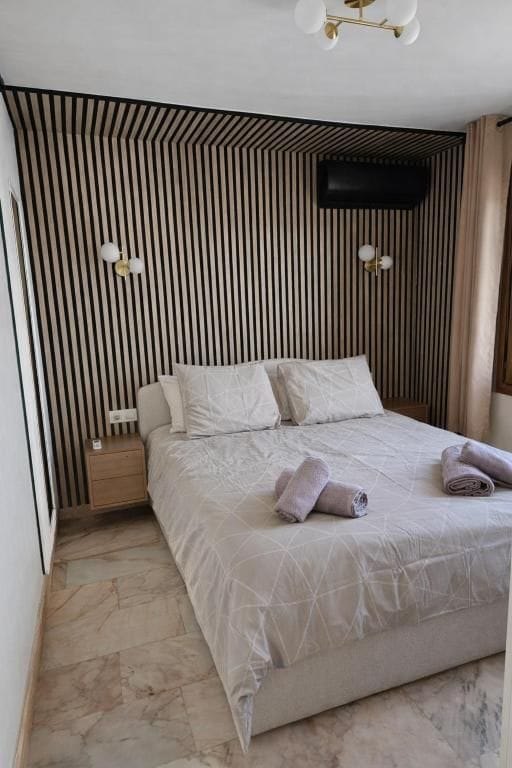 Double bedroom with wood-slat feature wall at Villa Andalucía